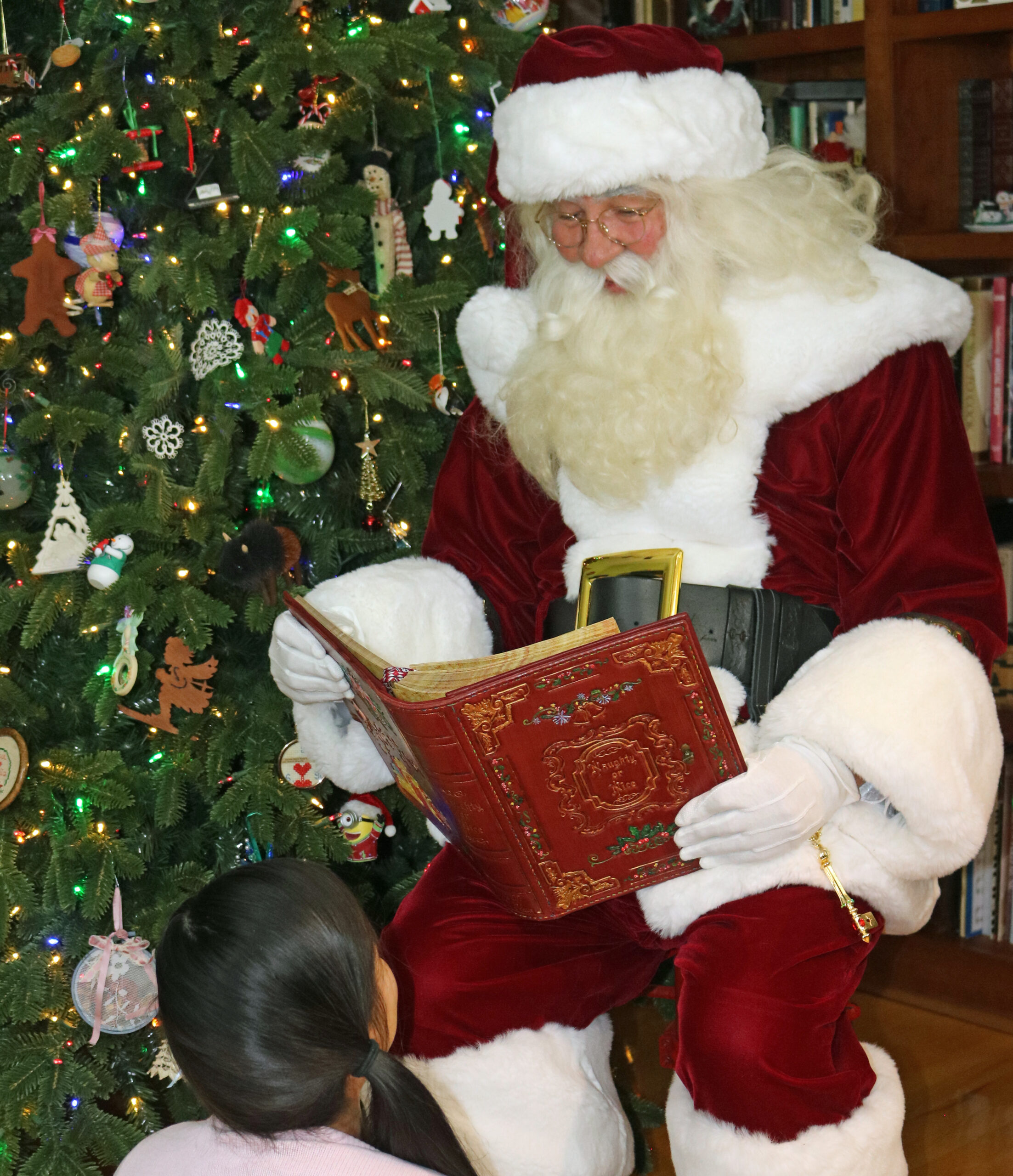 Santa Paul checking the Naughty or Nice Book for a child's name