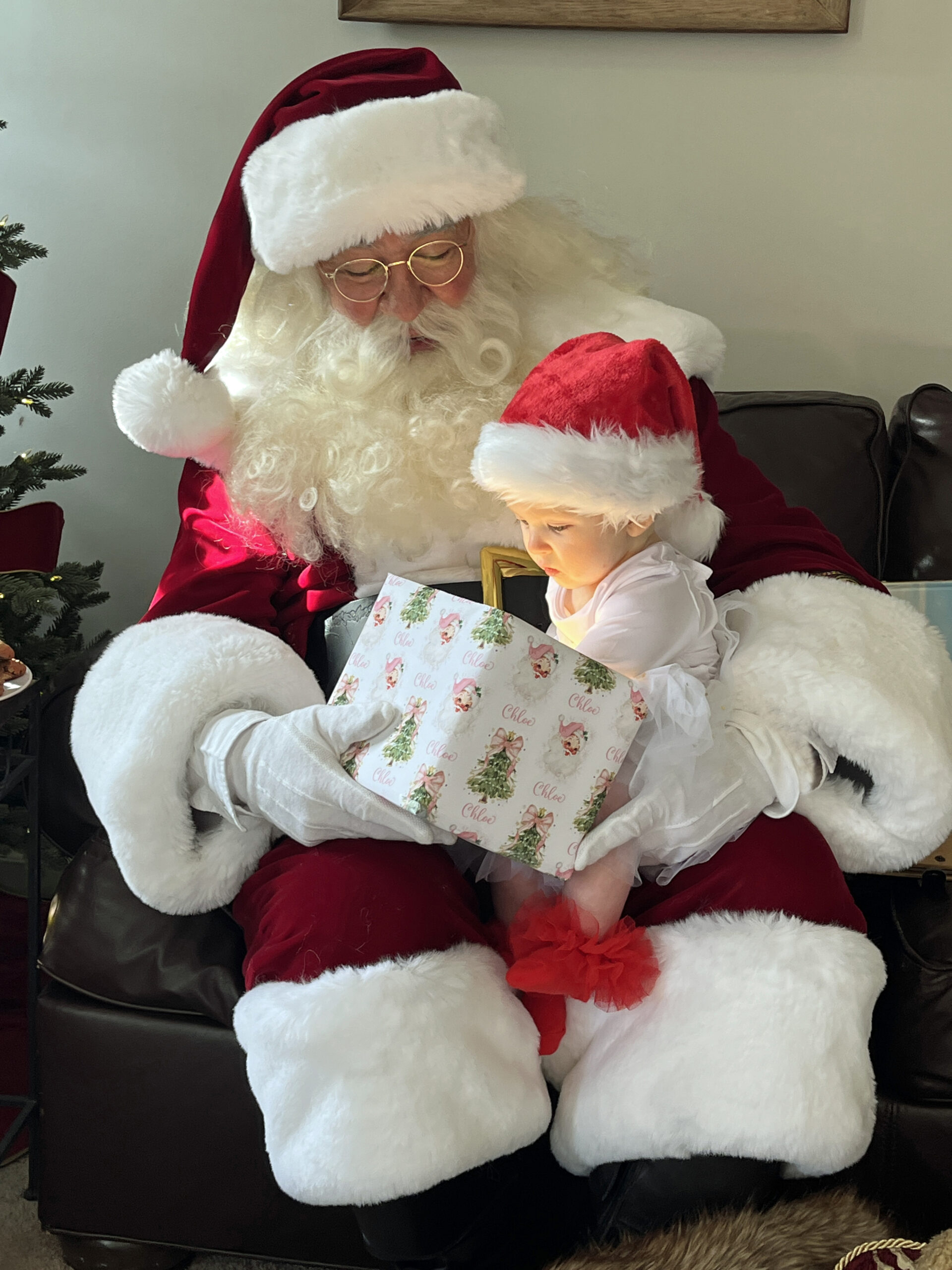 Santa and a little girl opening a present